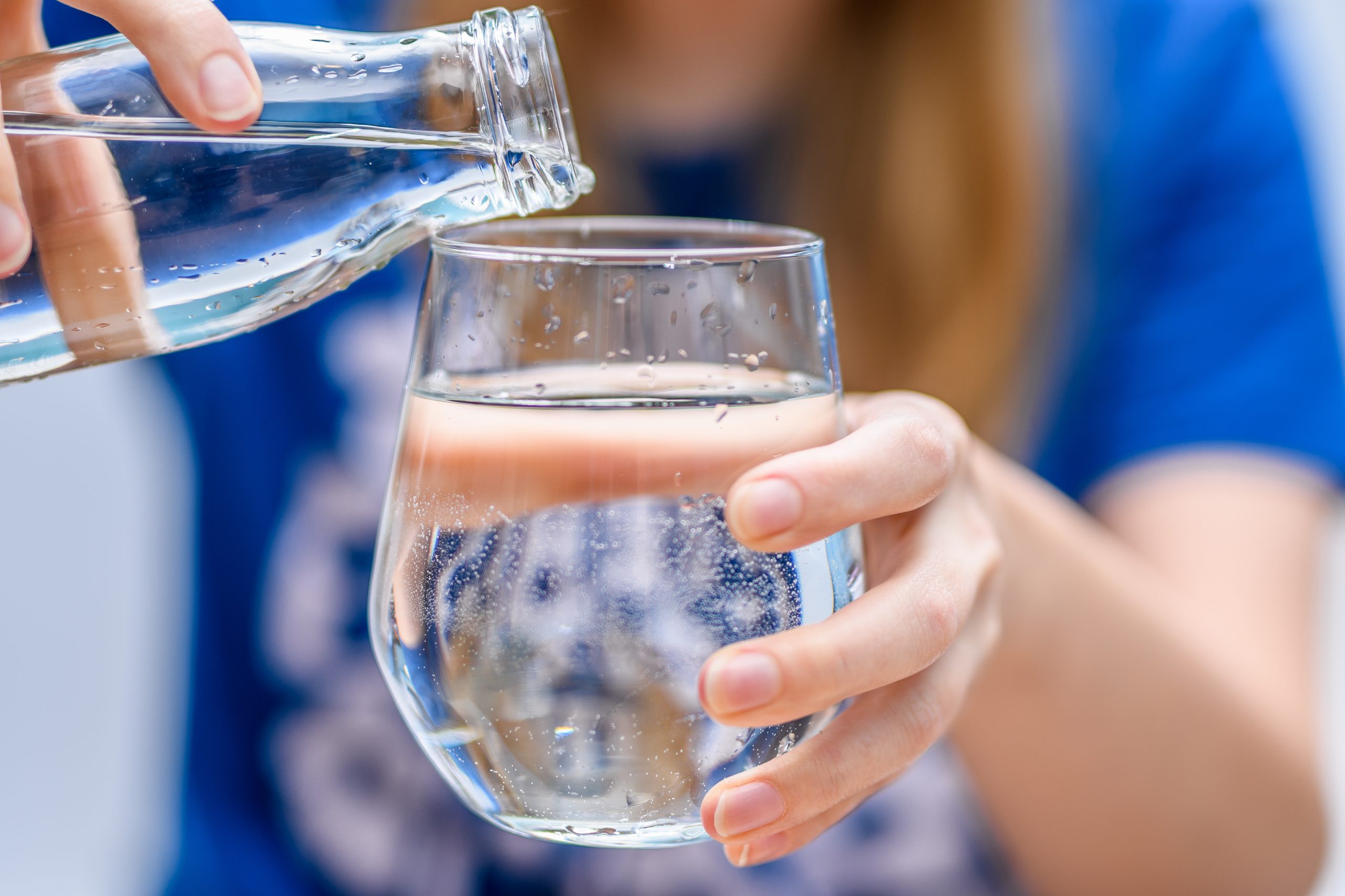 Glas Wasser, das getrunken wird um ein einfacher und wichtiger Tipp, um auch in der Weihnachtszeit ausreichend hydriert und energiegeladen zu bleiben.