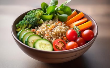 Eine Bowl mit Quinoa, Gurken, Tomaten und Karotten – eine gesunde Mahlzeit zur Unterstützung des Stoffwechsels in den Wechseljahren.
