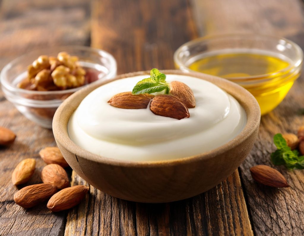 Eine Schale Joghurt mit Omega-3-reichem Bio-Leinöl und Nüssen – eine gesunde Kombination zur natürlichen Unterstützung des Sättigungsgefühls und zur Aktivierung von GLP-1.