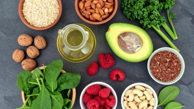 Ein Bild von frischen, lebendigen Lebensmitteln wie grünem Blattgemüse, Beeren, Nüssen und fermentierten Lebensmitteln, die eine gesunde Darmflora unterstützen.