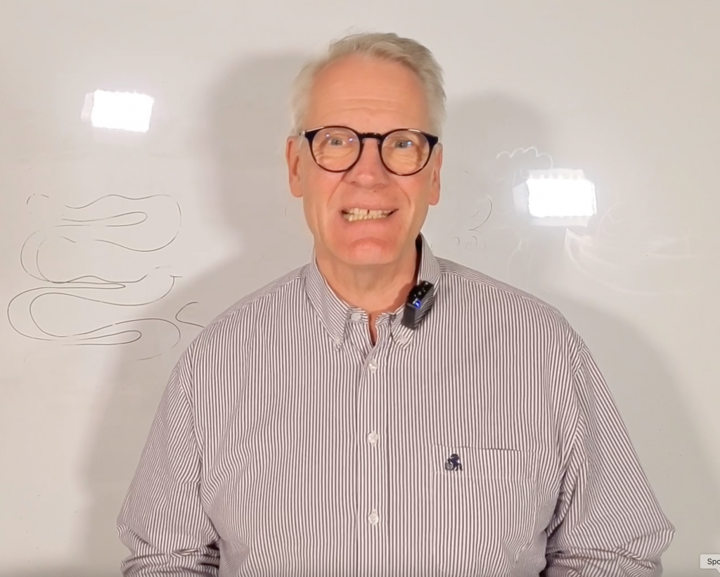 Carsten Meß steht vor einer Tafel und erklärt das ZellVitalSystem zur zellulären Gesundheitsversorgung im Gesundheitswesen