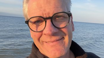 Carsten Meß bei einem zügigen Strandspaziergang an der Ostsee auf Usedom – Bewegung an der frischen Luft als Teil eines gesunden Lebensstils.